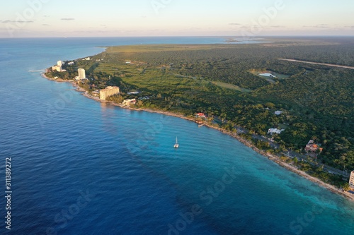 Coast line of Cozumel island with beach front hotels, turquoise blue ocean and tropical forest