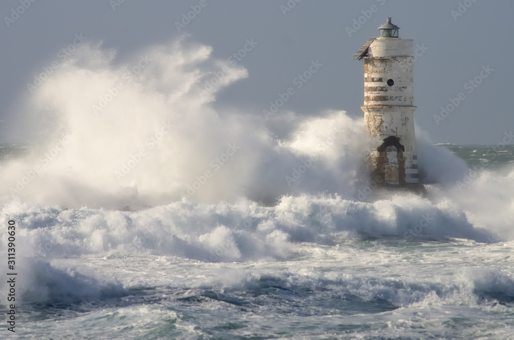 lighthouse shrouded in waves during a storm in the Mediterranean