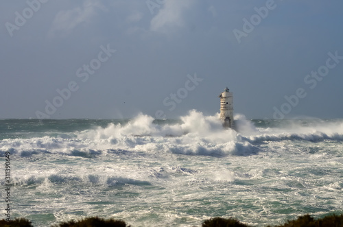 lighthouse shrouded in waves during a storm in the Mediterranean