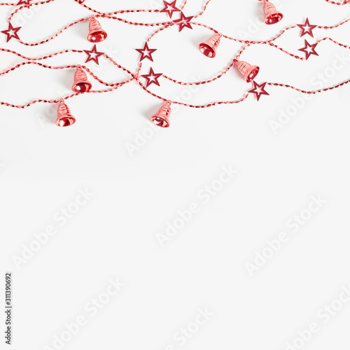 Christmas garlands with stars and bells red color on a white background. flat lay  square frame  copy space