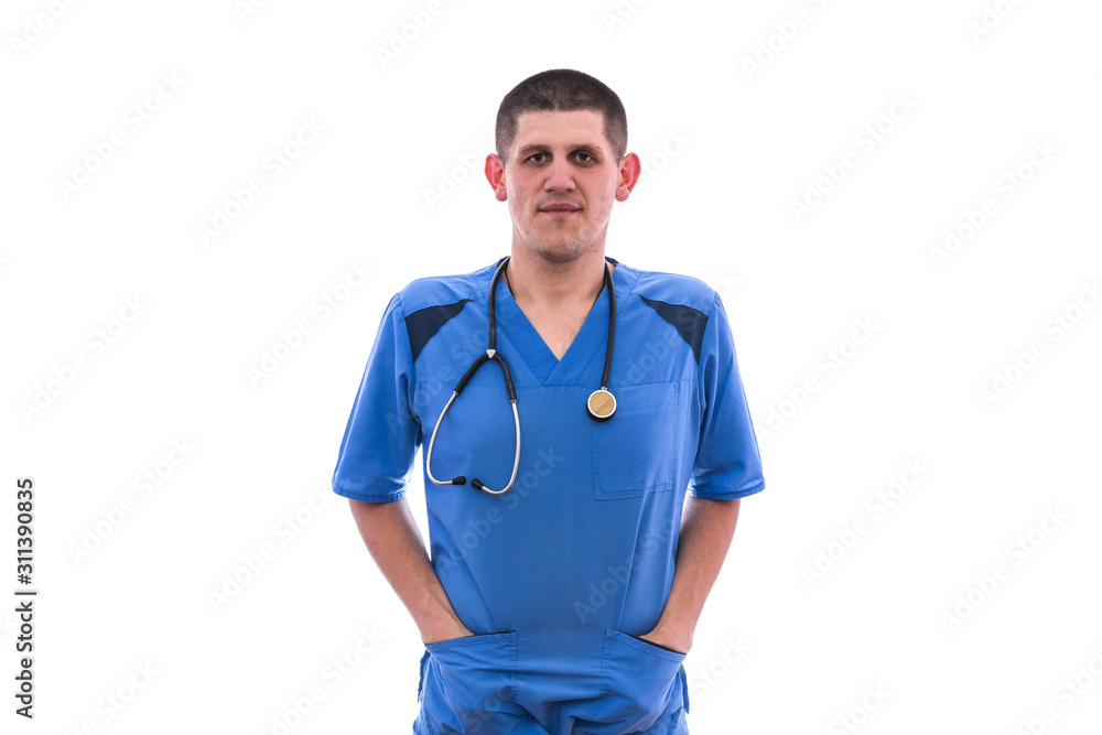 Doctor in uniform isolated on white. He is standing and putting his hands into pockets with stethoscope around his neck Doctor in uniform isolated on white. He is standing and putting his hands into pockets with stethoscope around his neck