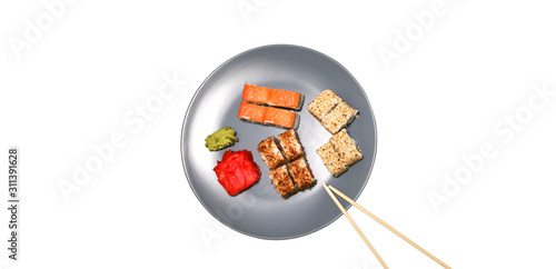 Sushi on the plates with chopsticks isolated. Romantic dinner in Japanese style. Salmon, wasabi and ginger. Healthy food concept. Vegetarian.