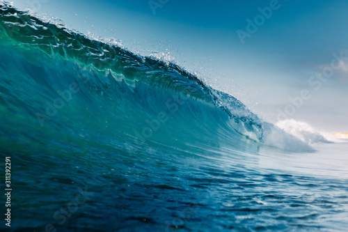 Blue crystal wave in ocean. Breaking wave and sun light