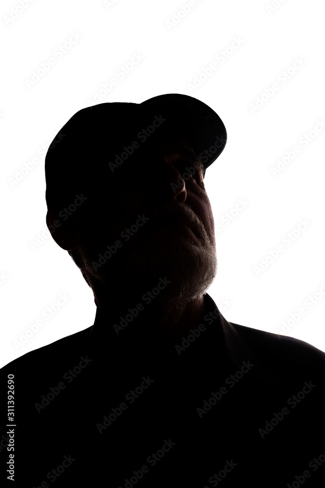 Old man in peaked cap, side view - dark close-up silhouette Old man in peaked cap, side view - dark close-up silhouette