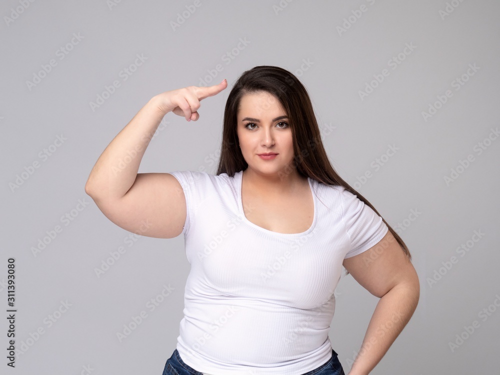 Portrait of serious plus size woman standing saluting with hand Portrait of serious plus size woman standing saluting with hand
