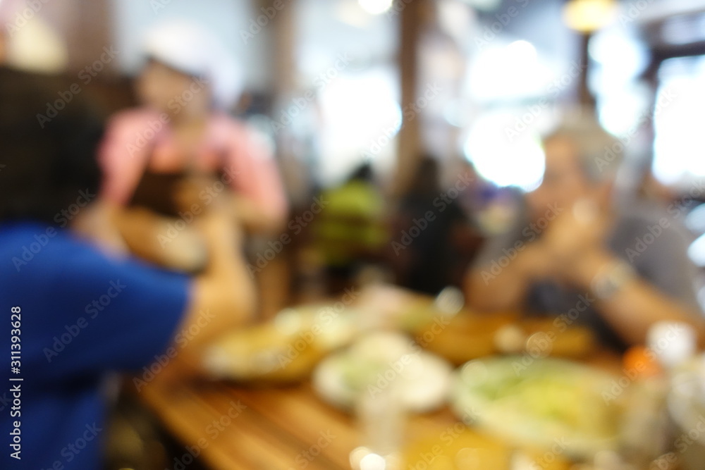 blurred image of group of people of enjoy talking and eating some food with their family on table in restaurant. vintage tone and light effect. Abstract restaurant interior for background blurred image of group of people of enjoy talking and eating some food with their family on table in restaurant. vintage tone and light effect. Abstract restaurant interior for background