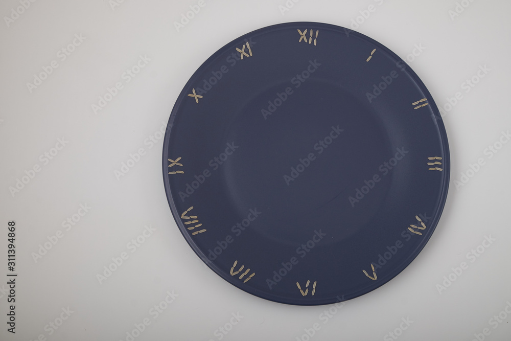 clock, time concept with rice on a blue plate, top view