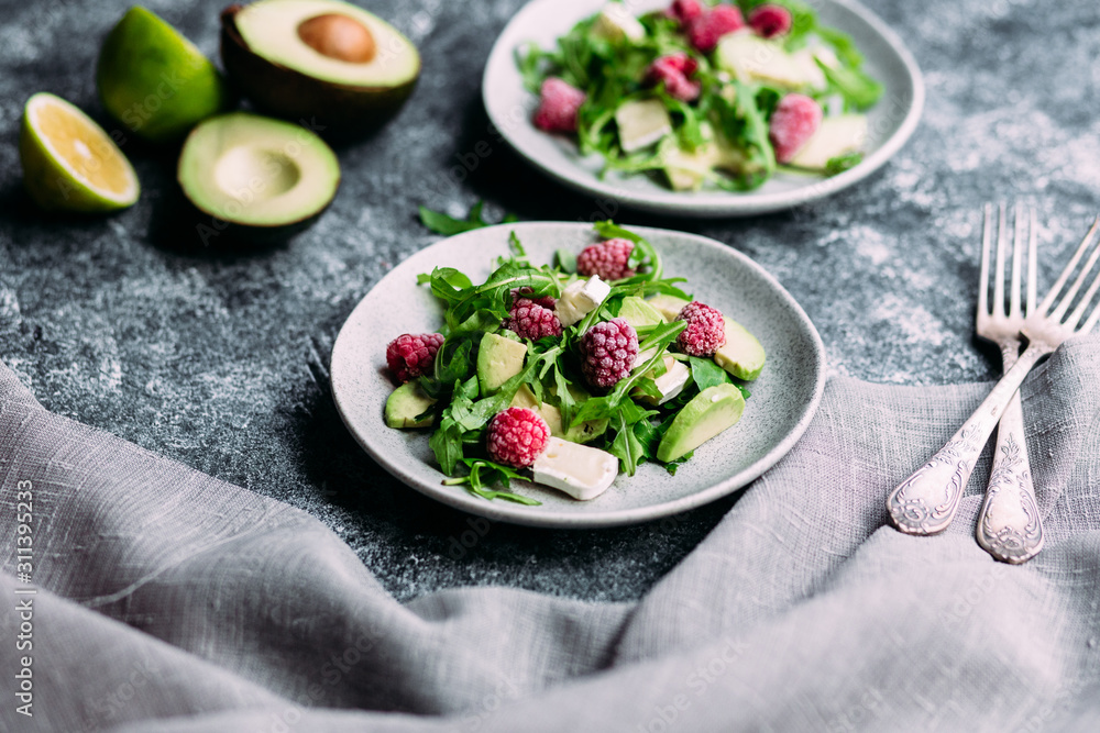 Salad with arugula, avocado, raspberries and brie cheese