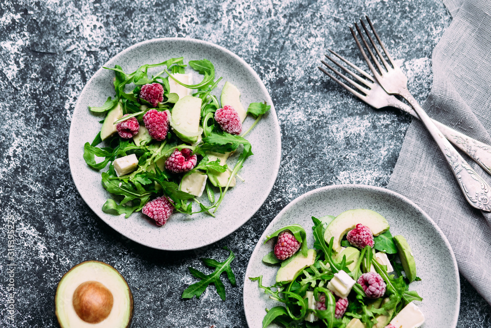 Salad with arugula, avocado, raspberries and brie cheese Salad with arugula, avocado, raspberries and brie cheese