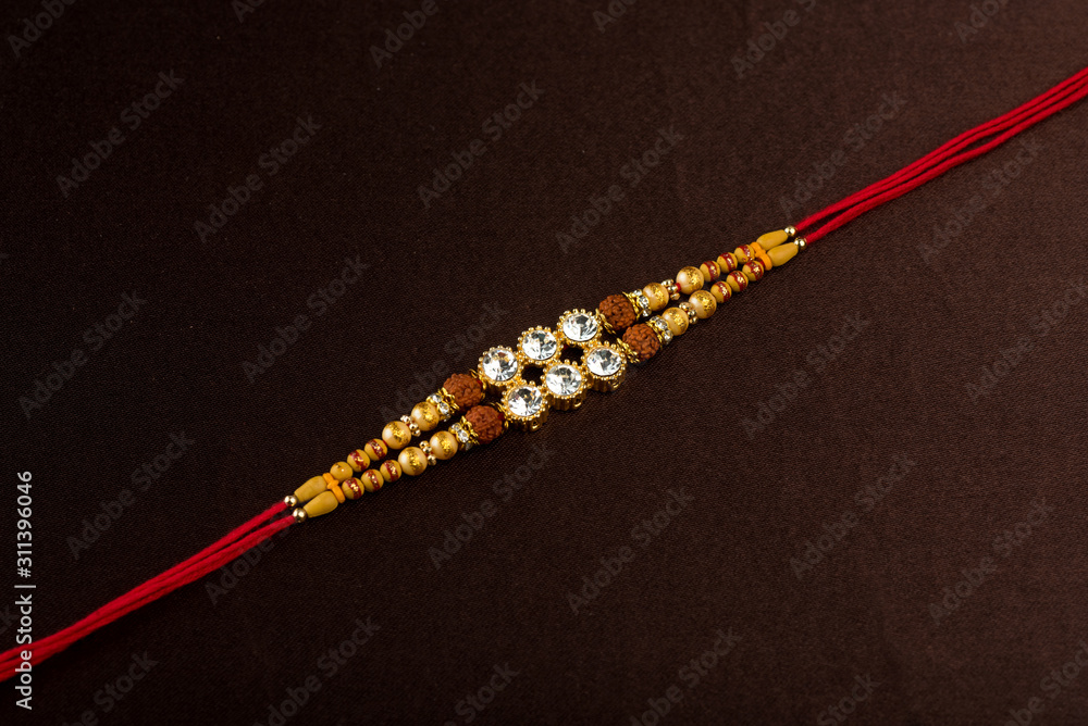 A Rakhi Raksha Bandhan background with an elegant Rakhi. A traditional Indian ...