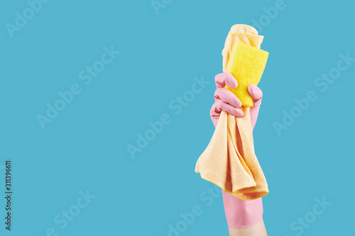 Hand of housewife showing kitchen soap and microfiber cloth she is using for cleaning the house