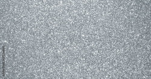 Silver glitter background, sparkling shimmer glow particles texture. Silver light sparks and glittering foil sequins background with shine sparks glare