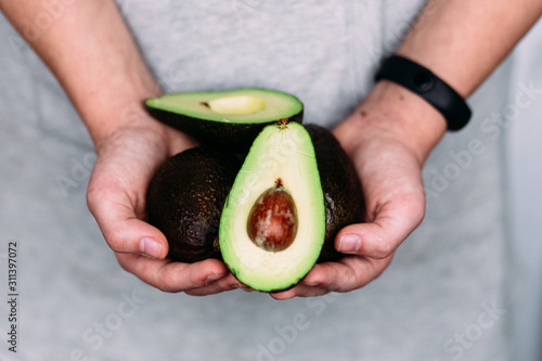 Avocado in the hands of a girl. Healthy nutrition