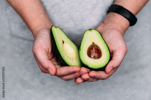 Avocado in the hands of a girl. Healthy nutrition