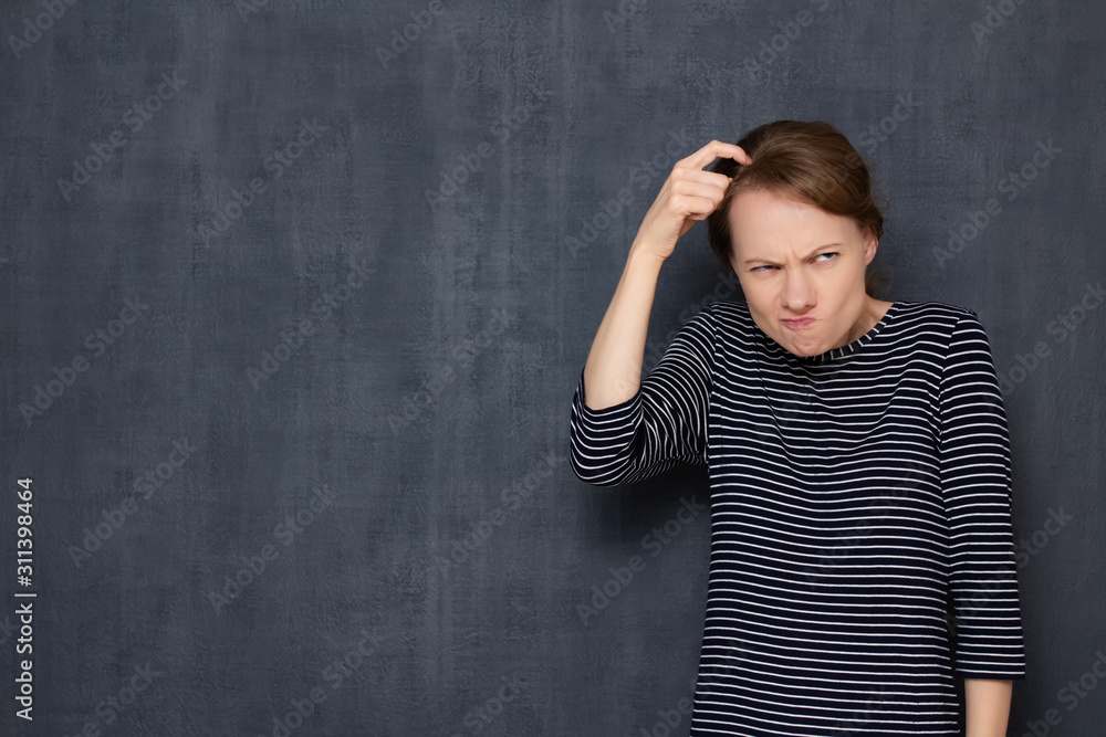 Portrait of funny focused confused girl scratching head with finger Portrait of funny focused confused girl scratching head with finger