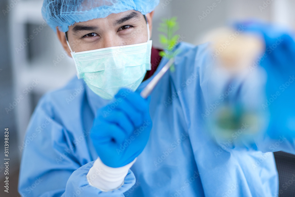 Asian scientists wear protective clothing while testing herbal medicines in the laboratory. And smiled at the camera Asian scientists wear protective clothing while testing herbal medicines in the laboratory. And smiled at the camera