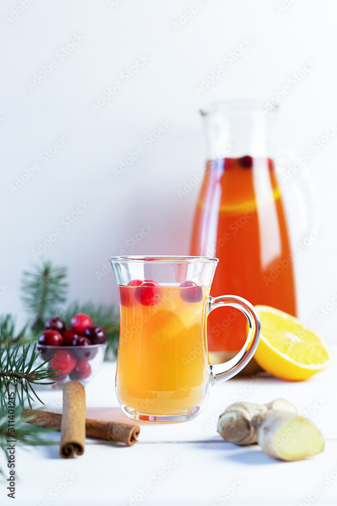 Orange and cranberry punch with orange slices and spices on a white table. Hot drinks for winter and Christmas. Orange and cranberry punch with orange slices and spices on a white table. Hot drinks for winter and Christmas.