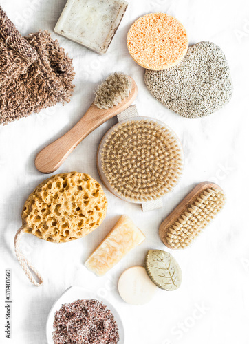 Body skin care. Brushes with natural bristles, pumice, homemade soap, scrub on a light background, top view photo