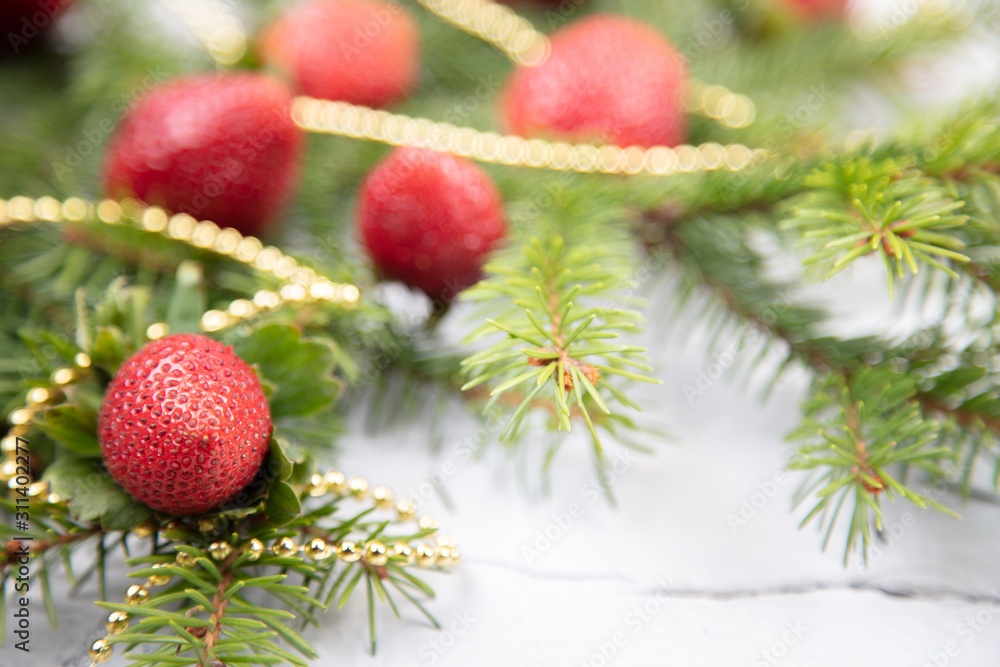 A beautiful sprig of spruce decorated with strawberries. Fresh strawberries close-up, decoration for the Christmas tree. A beautiful sprig of spruce decorated with strawberries. Fresh strawberries close-up, decoration for the Christmas tree.