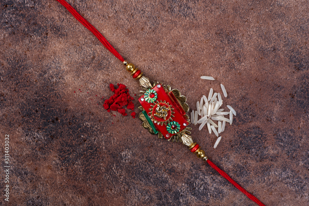 Raksha Bandhan : Rakhi with rice grains and kumkum on stone background ...