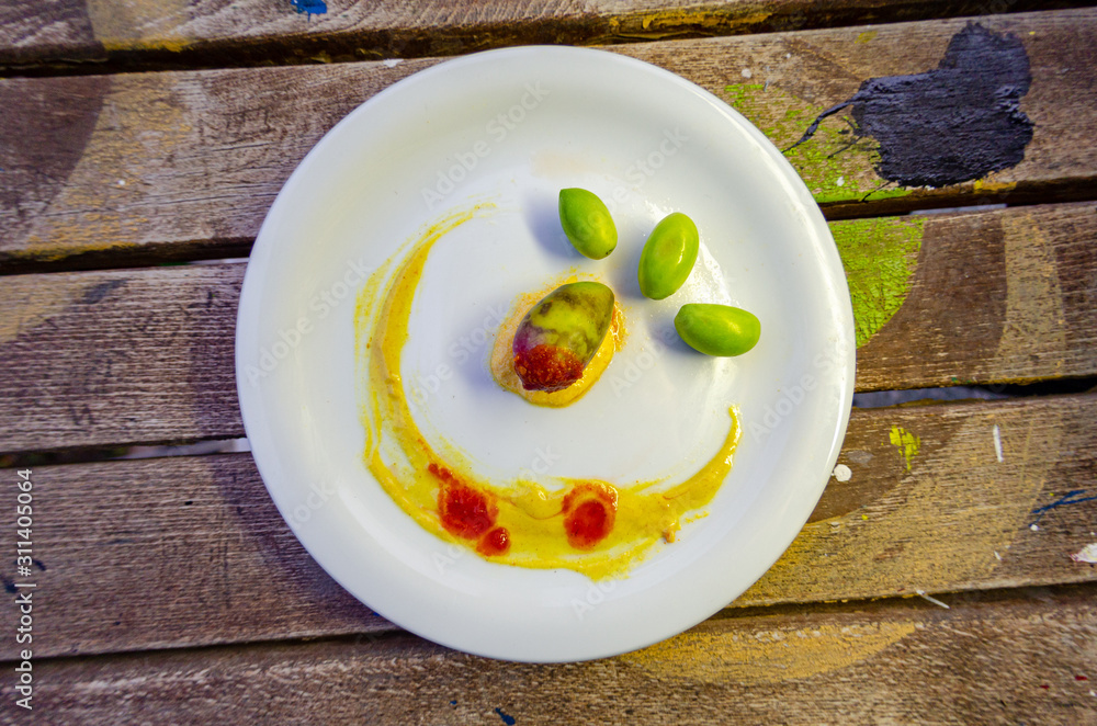 white plate with olives garnished with sauce white plate with olives garnished with sauce