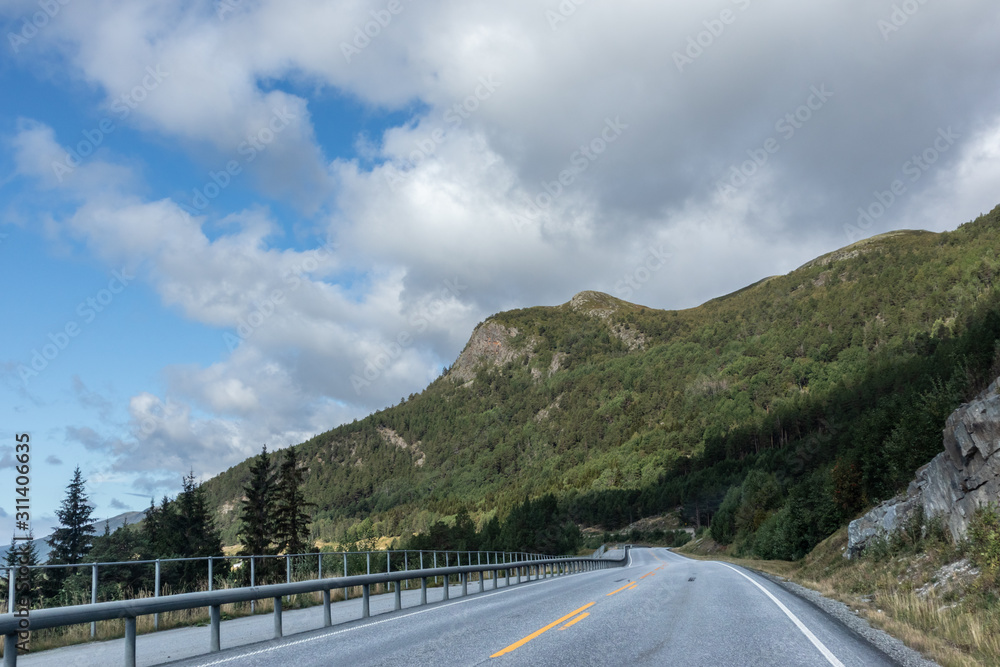 Mountains in Norway road epic scenic sky, way, clouds view. Traveling by car, driving nature tourism. Dramatic skyscape northern scandinavian sky Mountains in Norway road epic scenic sky, way, clouds view. Traveling by car, driving nature tourism. Dramatic skyscape northern scandinavian sky
