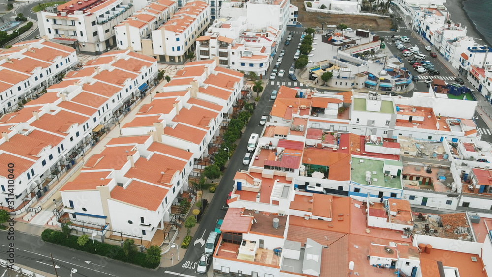 Aerial view. Tiled roofs of white resort houses off the coast of the Atlantic. The coastal city of Agaete, Gran Canaria.
