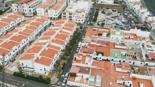 Aerial view. Tiled roofs of white resort houses off the coast of the Atlantic. The coastal city of Agaete, Gran Canaria. © Artem