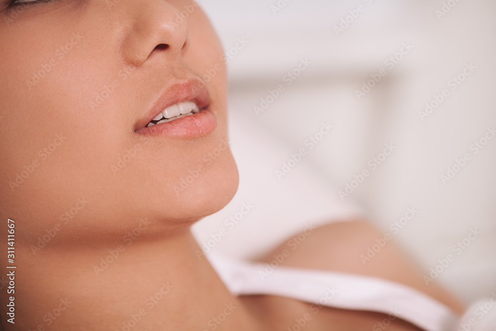 Cropped close up of the lips of a young woman with perfect unblemished skin, copy space. Facial treatment, lip augmentation concept