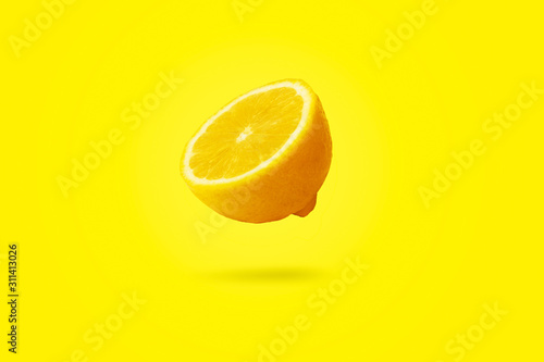sliced lemon levitating over yellow  background