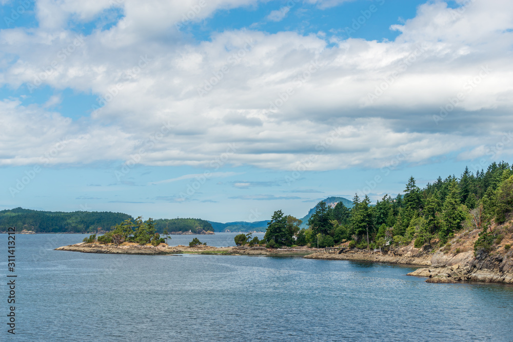 View over inlet, ocean and island with boat and mountains in beautiful British Columbia. Canada.