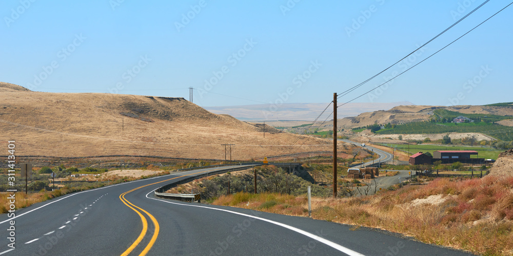 Panoramic view of the hills and curved road in Eastern Oregon.