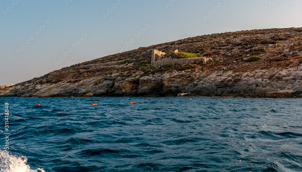 Rocky island in the Mediterranean sea, shot from the boat level.