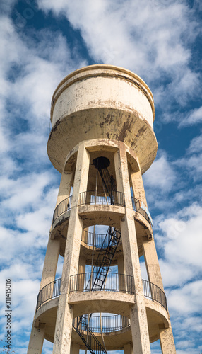 Old water tower. Vertical panoramic image. Clouds and dramatic sky in backgro...