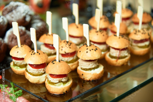 Set of mini burgers on a decorated table. © yallowww