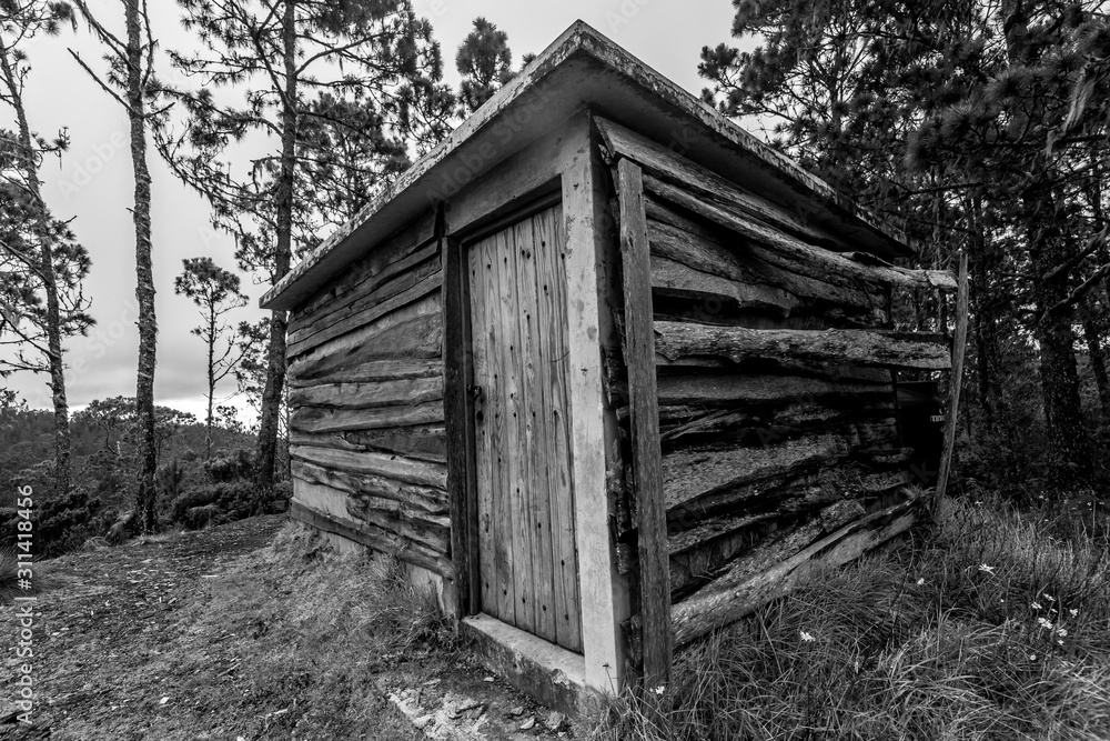 dramatic black and white image of an old wooden pump shack high in the caribbean mountains at Valle Nuevo National Park in the dominican republic.