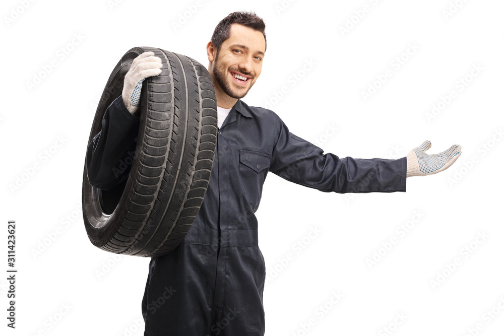 Auto mechanic with a tire gesturing welcome with hand Auto mechanic with a tire gesturing welcome with hand