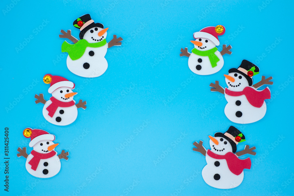 Funny snowmen in red and green scarves and black hats on a blue background Funny snowmen in red and green scarves and black hats on a blue background
