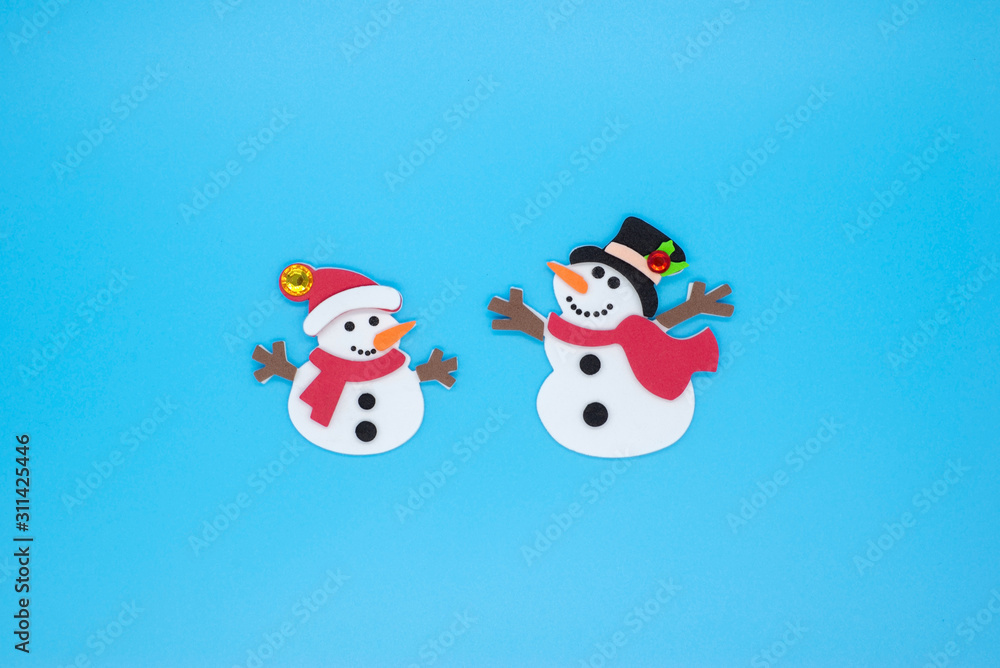 Funny snowmen in red and green scarves and black hats on a blue background Funny snowmen in red and green scarves and black hats on a blue background