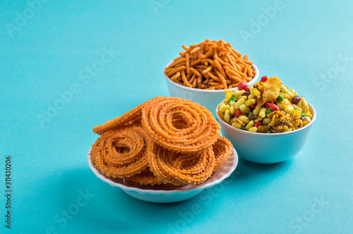 Indian Snack : Chakli, chakali or Murukku and Besan (Gram flour) Sev and chivada or chiwada on blue background. Diwali Food photo