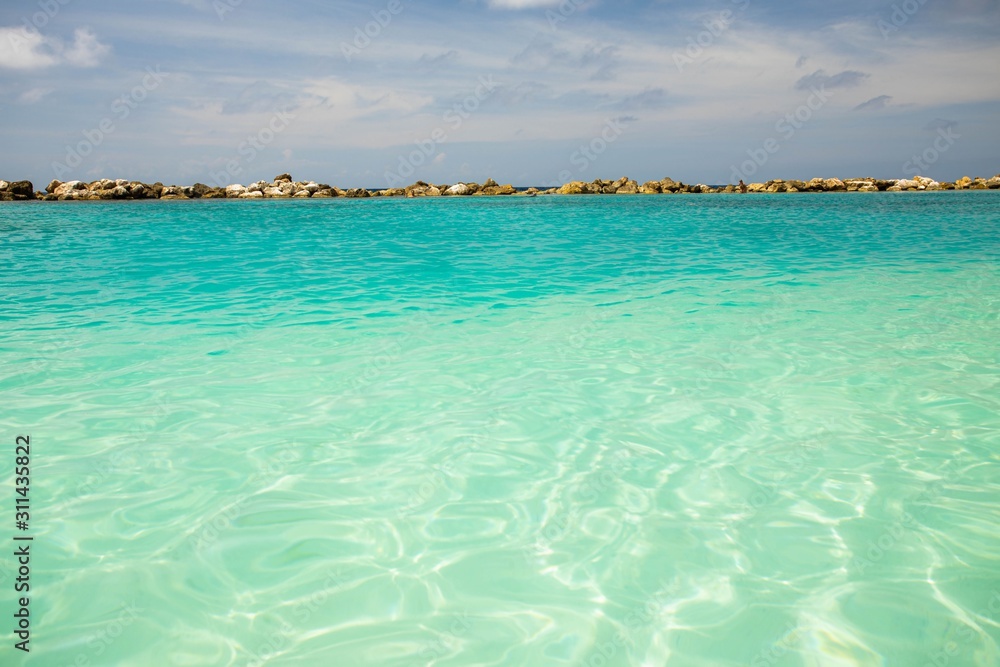 Amazing view of turquoise water of Atlantic ocean and blue sky with white clouds. Curacao island.. Beautiful nature background. Amazing view of turquoise water of Atlantic ocean and blue sky with white clouds. Curacao island.. Beautiful nature background.