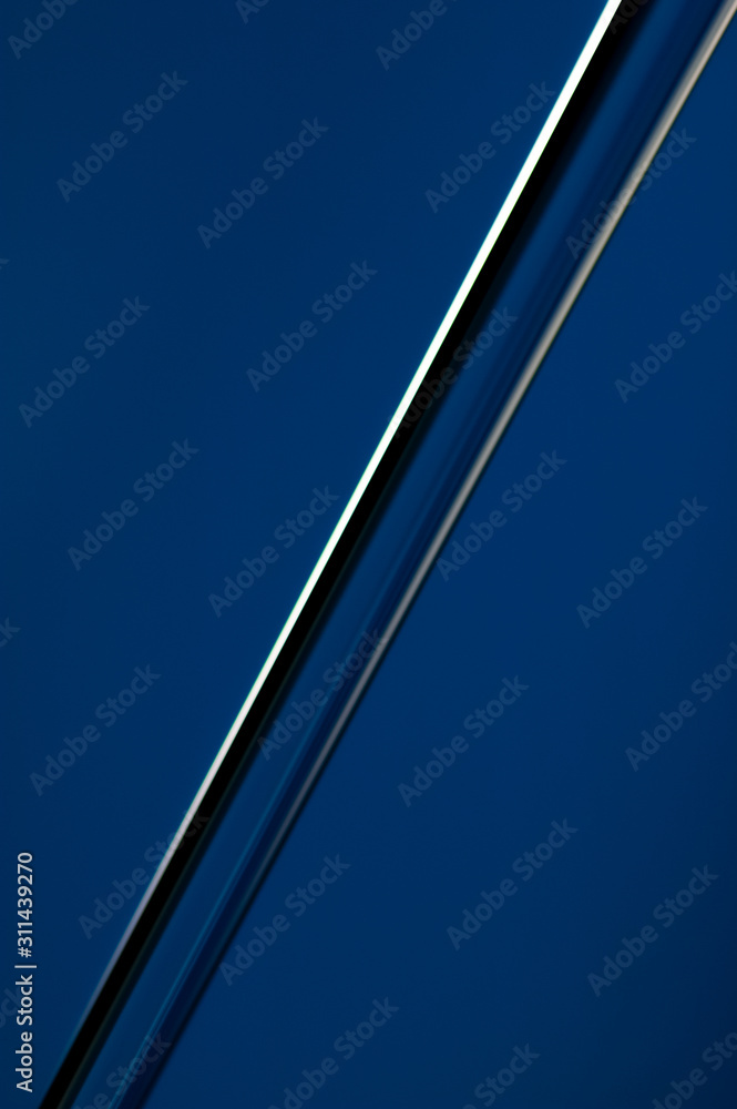A diagonal stream of water on a blue background in close-up. Abstraction. A diagonal stream of water on a blue background in close-up. Abstraction.
