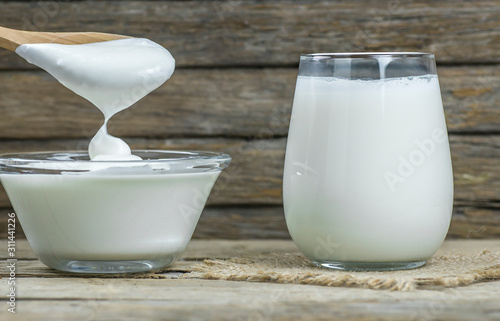 Glass cup of Turkish traditional drink ayran , kefir or buttermilk made from yogurt, homemade yoghurt in glass bowl on rustic table, healthy food