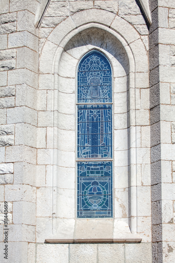 narrow church window on the white wall