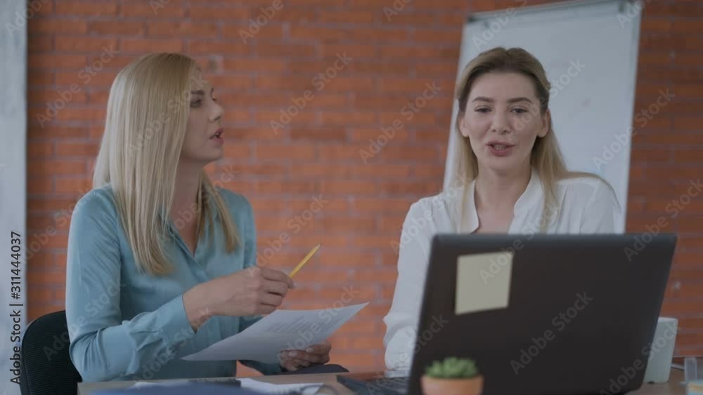 Two successful business women are working on a project at a computer. Modern laptop modern technology. Beautiful fashionable office. 4K Two successful business women are working on a project at a computer. Modern laptop modern technology. Beautiful fashionable office. 4K