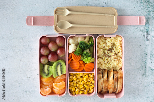 Photos Porridge, chicken, salad, fruits - healthy balanced lunch box on a grey background