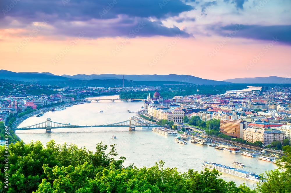 Obraz premium A view along the Danube River of Budapest, Hungary from Gellert Hill at sunset.