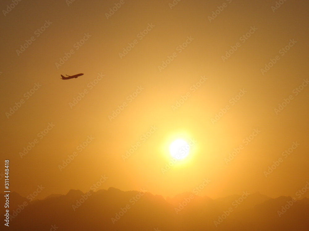 The amazing sunset is near the flying plane, Egypt