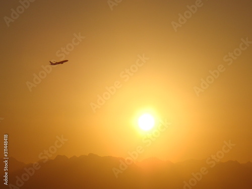 The amazing sunset is near the flying plane, Egypt