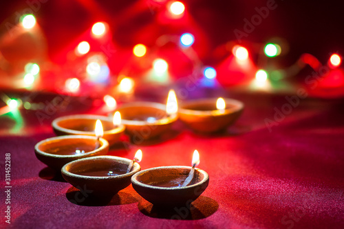 Clay diya lamps lit during Diwali Celebration. Greetings Card Design Indian Hindu Light Festival called Diwali photo